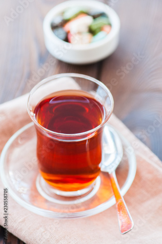 Turkish tea in authentic glass cup with delights. Closu up.