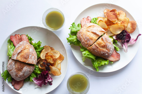 top view of the perfect Sunday brunch, sandwiches, potato and fresh green juice with white background.