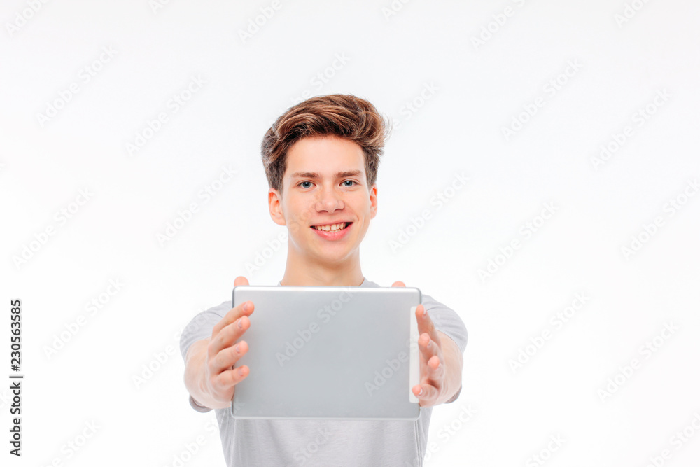 Attractive young man holding tablet in hands and smiling on whit Attractive young man holding tablet in hands and smiling on whit