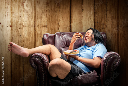 Asian fat man eating donuts on plate