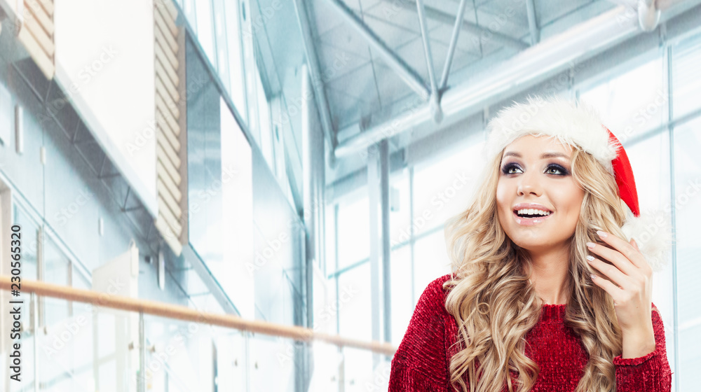 Fototapeta premium Portrait of female model in santa hat. Happy woman, Christmas and New Year party concept