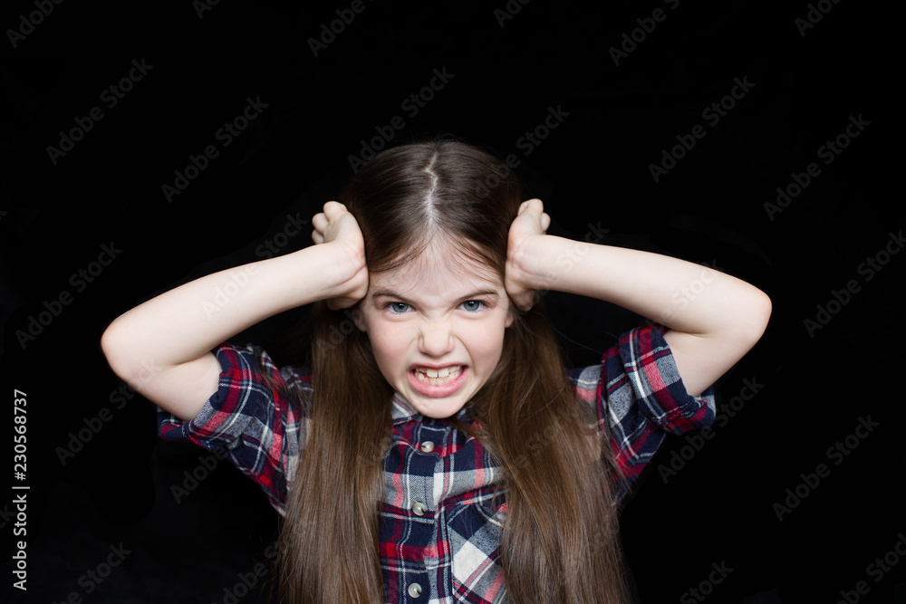Fototapeta premium portrait of angry girl on black background, problems with parents concept