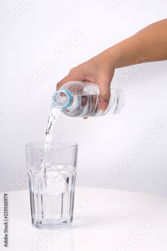 Hand Pouring water from a bottle in to a glass