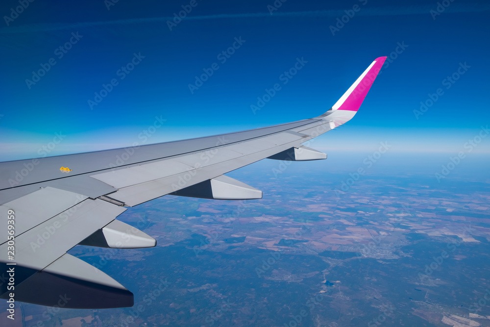 Fototapeta premium View to Airplane wing out of porthole window