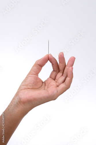 The hand holding the toothpick. Close up. Isolated on white background