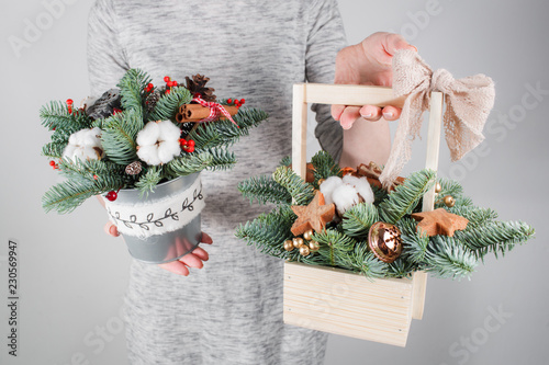 young woman holding christmas compositionin hands in light, seasonal holidays, rustic theme, adorning photo