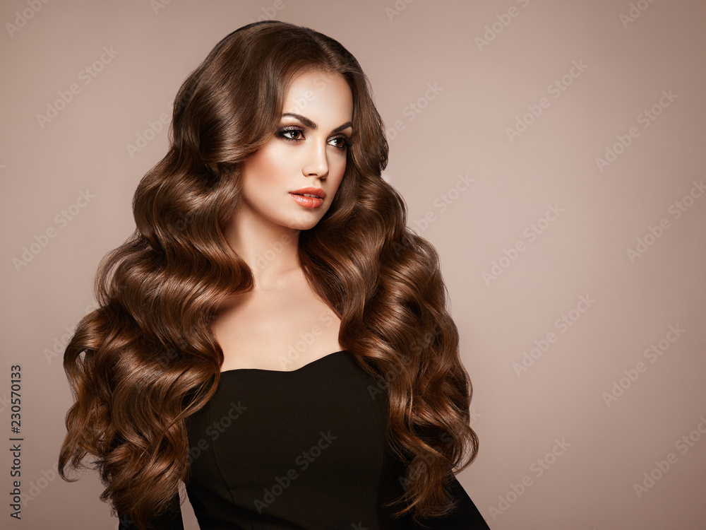 Brunette Girl with Long Healthy and Shiny Curly Hair. Care and Beauty.  Beautiful Model Woman with Wavy Hairstyle. Make-Up and Black Dress Stock  Photo | Adobe Stock
