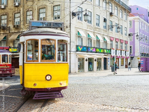 Vintage yellow tram in the city center on the sunny spring day, Praca da Figueira, Lisbon, Portugal.