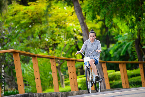Young beautiful woman riding a bicycle in a park