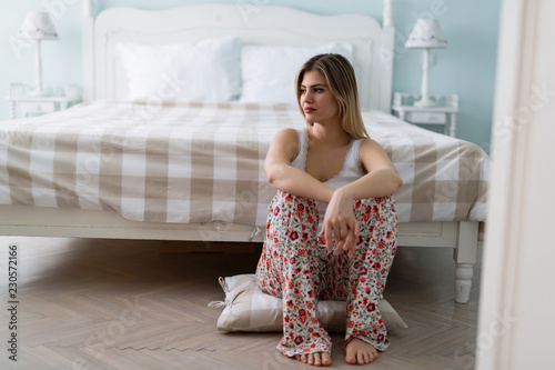 Portrait of sad young woman in bedroom