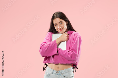 Businesswoman hugging laptop. Love to computer concept. Attractive female half-length front portrait, trendy pink studio backgroud. Young emotional pretty woman. Human emotions, facial expression