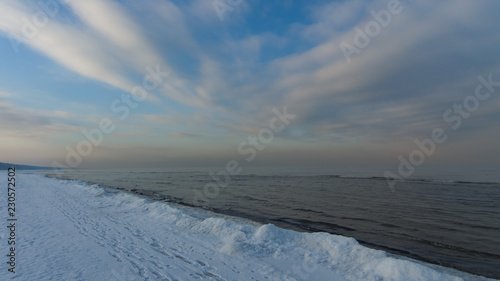 Winter shoreline of baltic sea with snow and ice under blue sky with clouds, selective focus © argenlant
