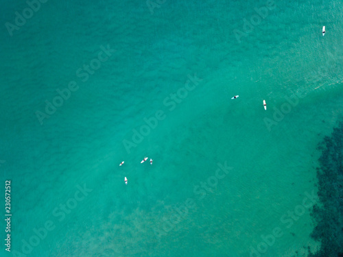 Some surfers sitting in the calm of the water © Brandan