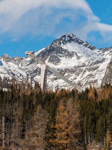 Winter in High Tatras. Winter view of frozen surface of Strbske Pleso  Tarn  with hotel and peaks of High Tatra mountains in background. Winter lake  mountains and blue sky.
