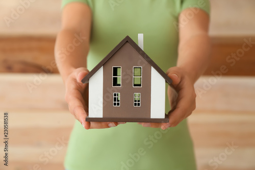 Woman with model of house o...