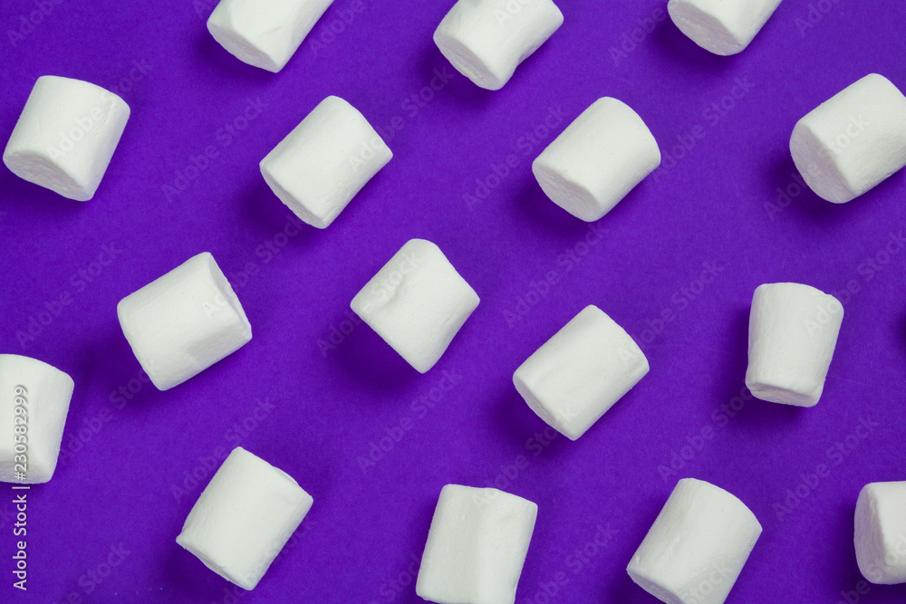 marshmallow laid out on violet paper background. marshmallow laid out on violet paper background.