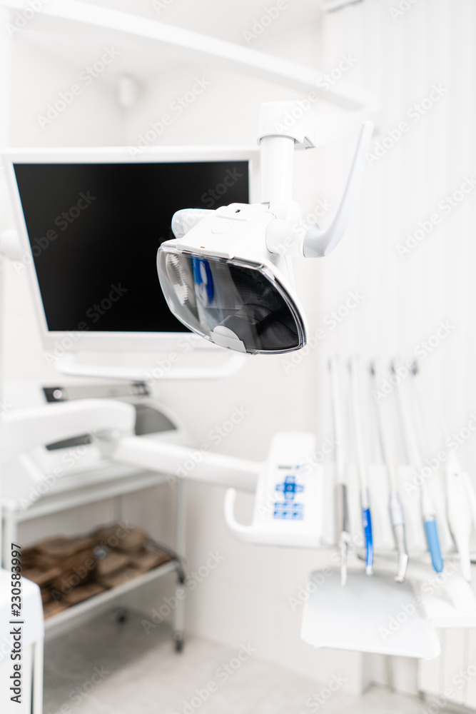 Modern led lamp in the dentists clinic. Dental work in clinic. Operation, tooth replacement. Medicine, health, stomatology concept. Office where dentist conducts inspection and concludes. Modern led lamp in the dentists clinic. Dental work in clinic. Operation, tooth replacement. Medicine, health, stomatology concept. Office where dentist conducts inspection and concludes.