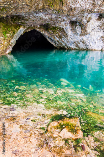 Water cave with pure vibrant aqua under the massive rocks