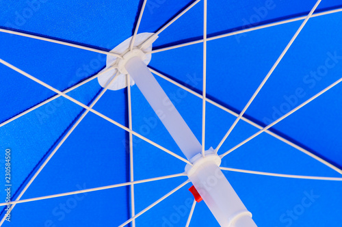 The internal metal plastic design of a blue textile parasol