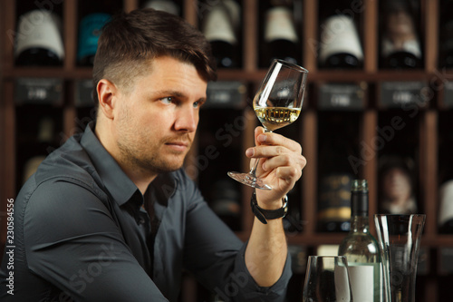 Sommelier looking at wine glass with beverage