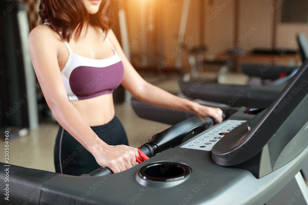 portrait of young healthy and sporty woman using exercise machine in gym (this image for fitness and workout concept) portrait of young healthy and sporty woman using exercise machine in gym (this image for fitness and workout concept)