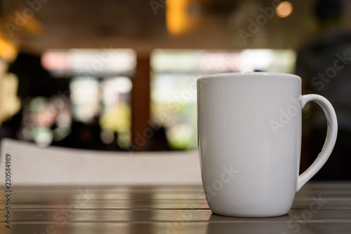 Coffee cup on wooden table in restaurant with defocused backgrou