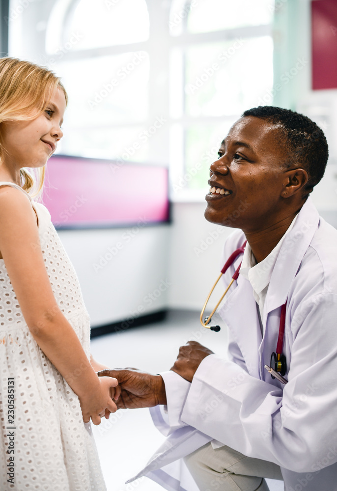 Friendly pediatrician talking to her little patient Friendly pediatrician talking to her little patient