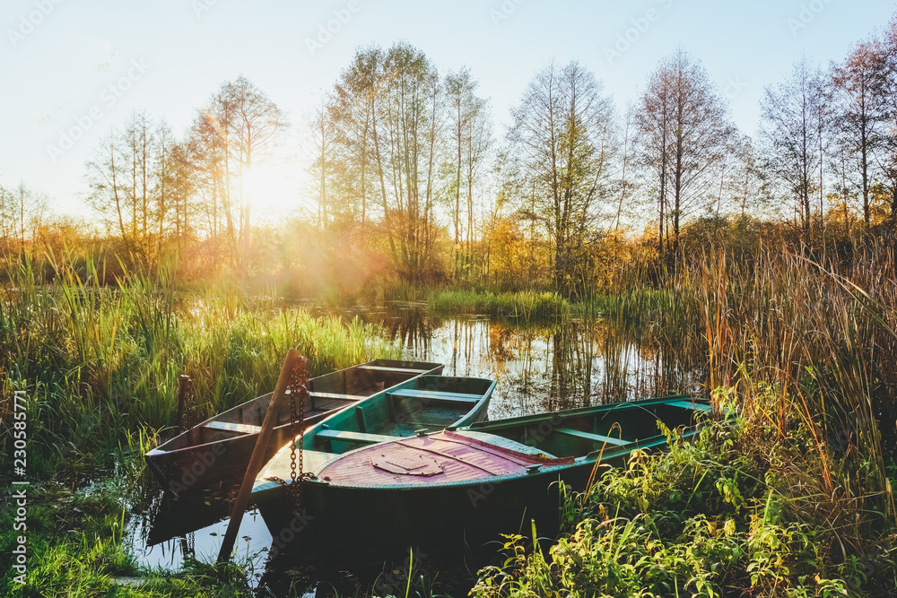 Autumn landscape on the river at sunset with boats Autumn landscape on the river at sunset with boats