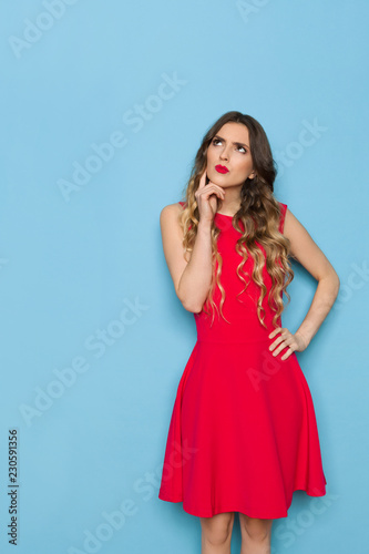 Beautiful Young Woman In Red Dress Is Looking Up And Planning