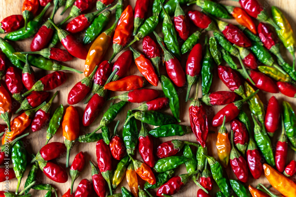 Colorful Chilli Peppers On Wooden Table. High Angle View Close Up Colorful Chilli Peppers On Wooden Table. High Angle View Close Up