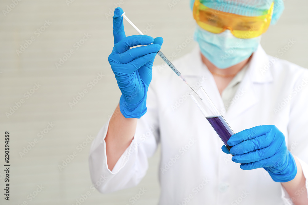 scientist woman with equipment and laboratory glassware holding chemical liquid and checking result using as science research background