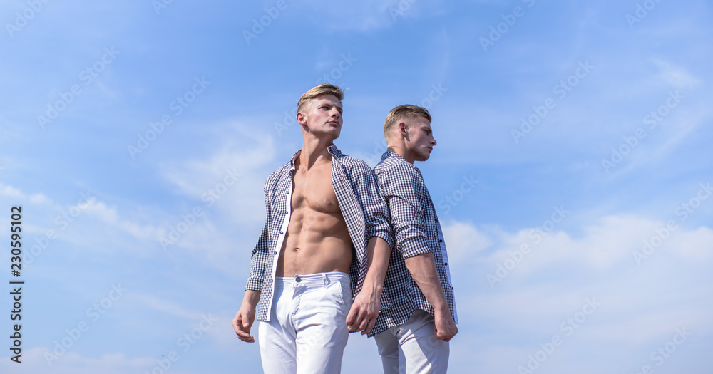 Men strong athlete wear same shirts. Brothers twins looks attractive. Fashionable similar outfits. Men twins brothers muscular guys posing in shirts sky background. Menswear and fashion concept Men strong athlete wear same shirts. Brothers twins looks attractive. Fashionable similar outfits. Men twins brothers muscular guys posing in shirts sky background. Menswear and fashion concept