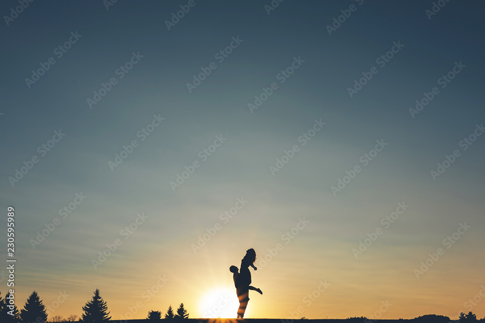 Silhouette frame, the guy keeps the girl in his arms Silhouette frame, the guy keeps the girl in his arms