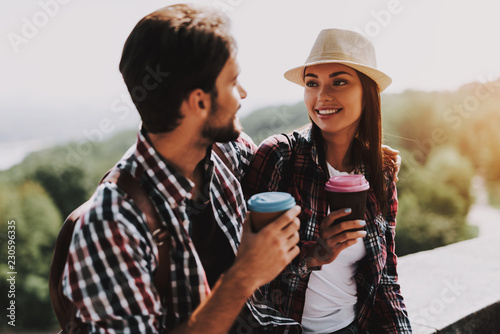 Happy Couple Sitting on Ledge and Drinking Coffee © VadimGuzhva