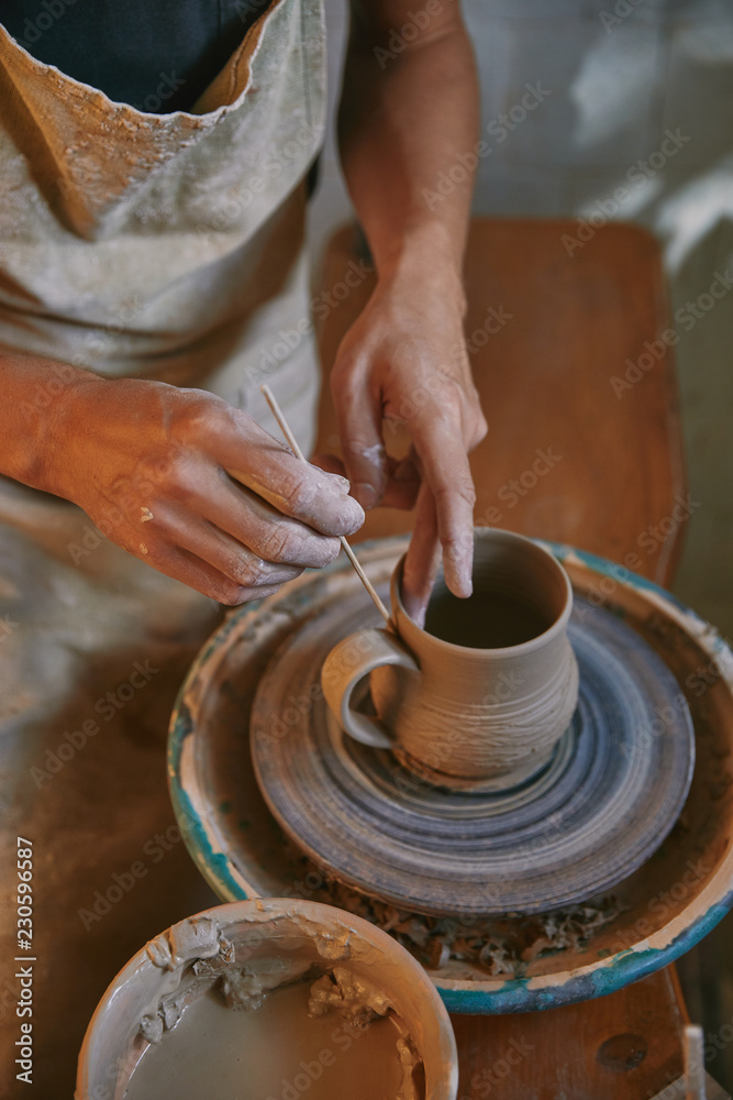 partial view of man decorating clay pot at workshop partial view of man decorating clay pot at workshop
