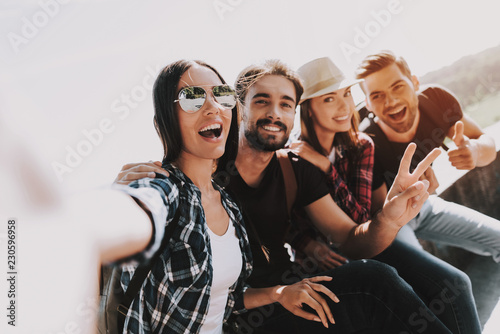 Young Smiling People Sitting in Park taking Selfie