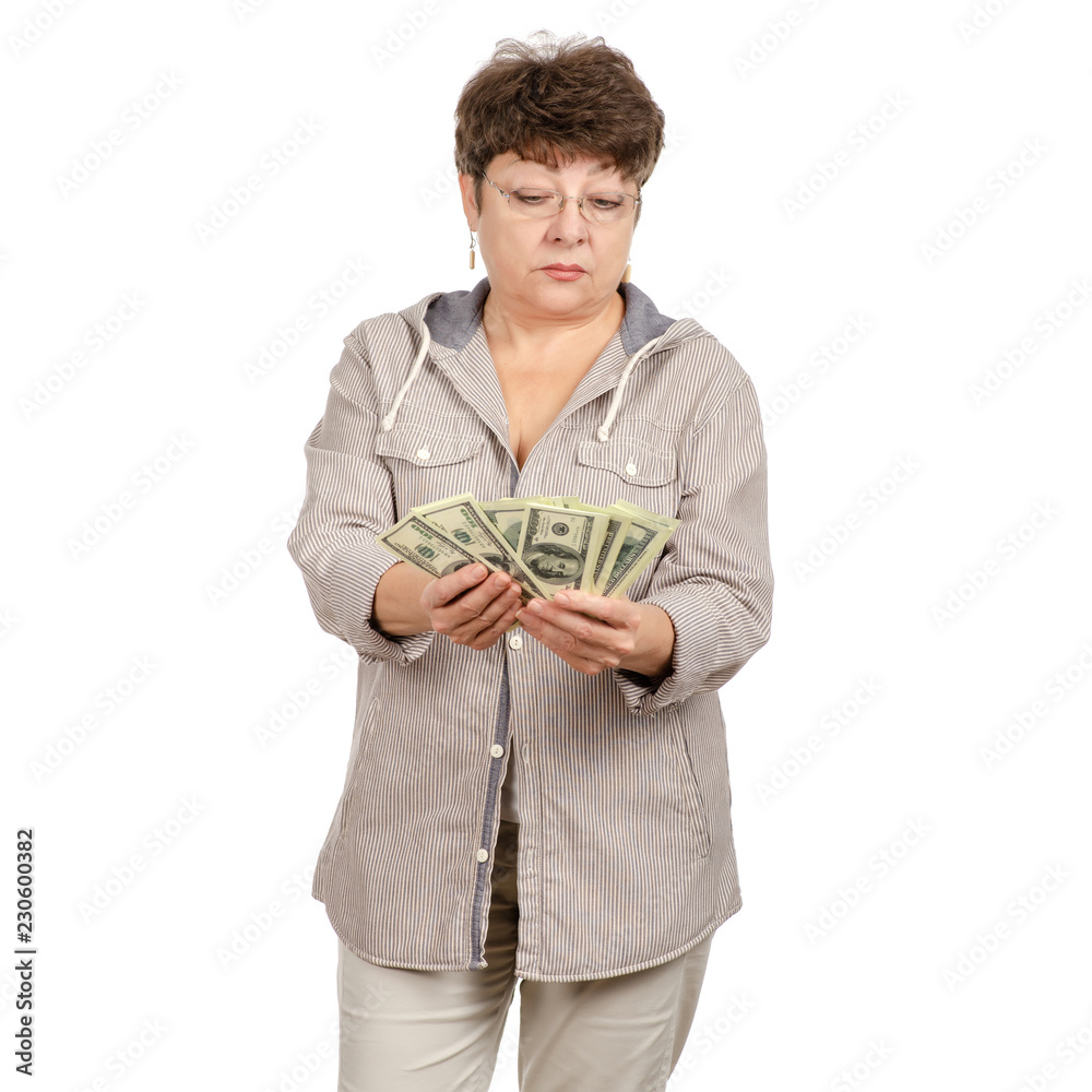 Beautiful woman aged smiling with glasses dollars in hands on a white background. Isolation Beautiful woman aged smiling with glasses dollars in hands on a white background. Isolation