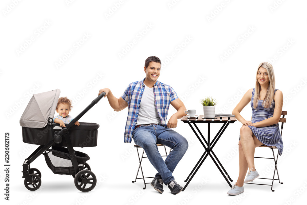 Father and mother with a baby in a stroller sitting at a coffee table and looking at the camera Father and mother with a baby in a stroller sitting at a coffee table and looking at the camera