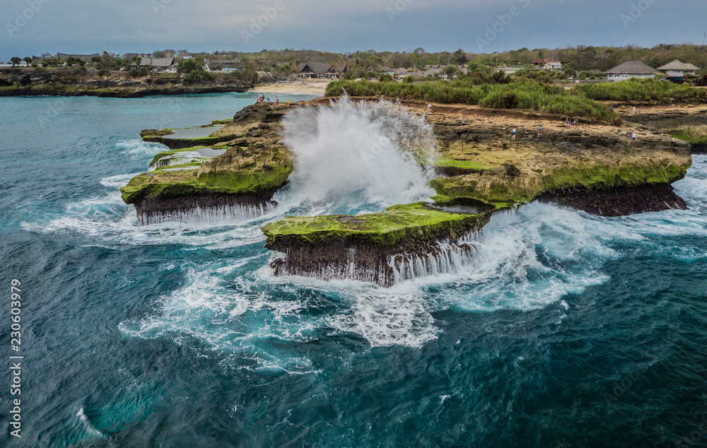 Giant wave breaking on Nusa Lembongan cliffs in Bali photo taken with a drone