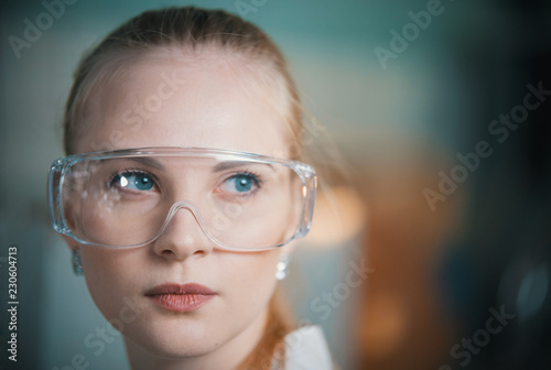 A young woman in work glasses in the lab