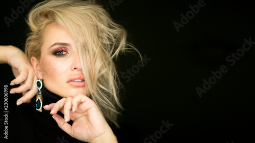 Beautiful young lady with make up face. Close-up of an attractive girl of European appearance on dark background