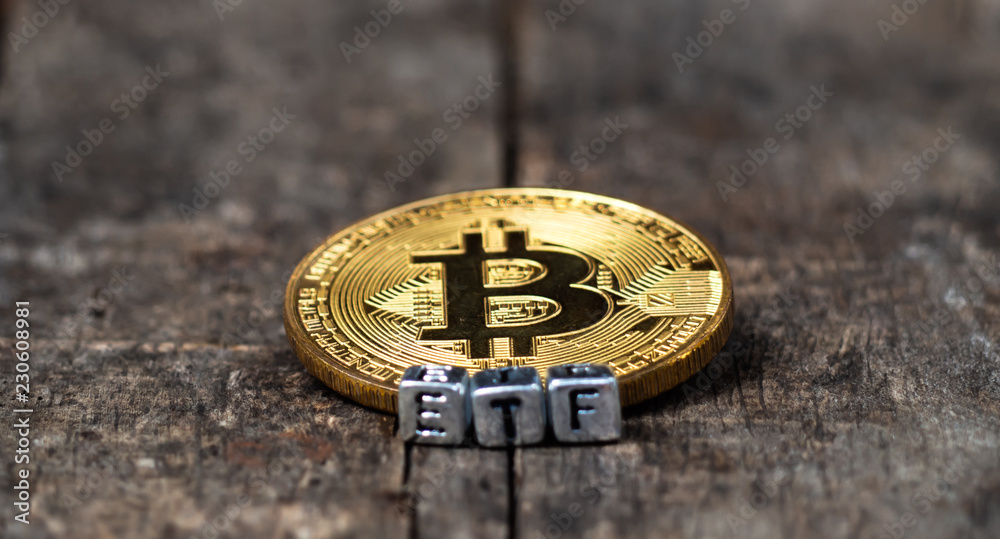 Bitcoin coin with ETF text Put on  wooden floor, Concept Entering the Digital Money Fund.