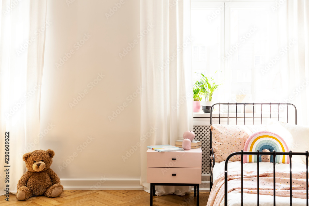 Teddy bear on a floor in a teenage room interior with an empty wall ...