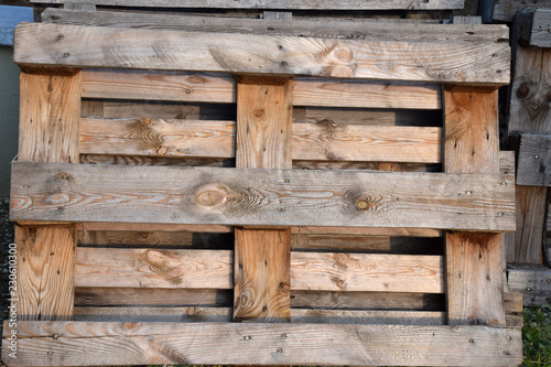 wooden pallets suitable for furniture processing, weathered wooden pallets in a row stored outdoors