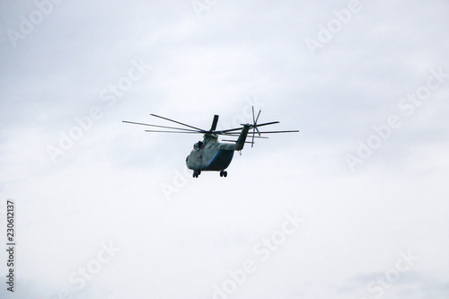 Fototapeta Naklejka Na Ścianę i Meble -  a large military helicopter hovers in the sky. A camouflaged helicopter flies at high speed.