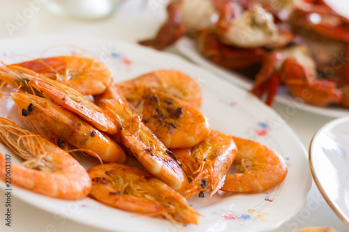 Grilled prawns plate. Fried shrimps appetizer dish. Crab legs on background, seafood dinner concept