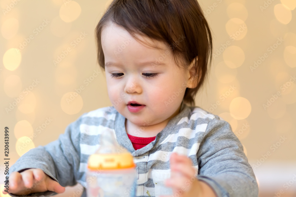 Toddler boy drinking juice in his house