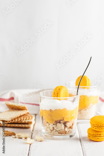 Lemon souce, mascarpone cream cheese and biscuit. Layered dessert in glass.