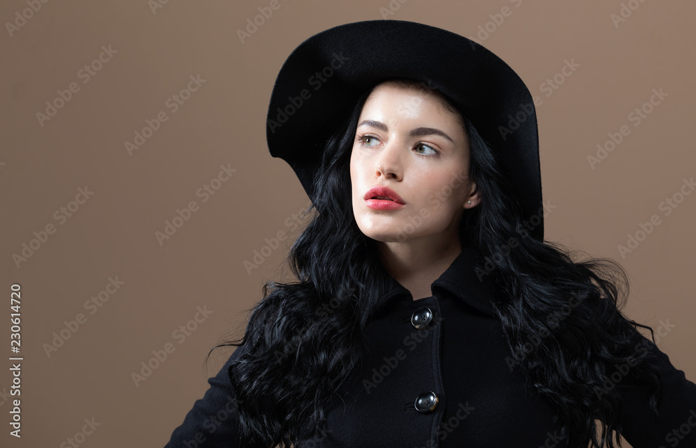 Beautiful young woman in a fashionable coat on a brown background Beautiful young woman in a fashionable coat on a brown background