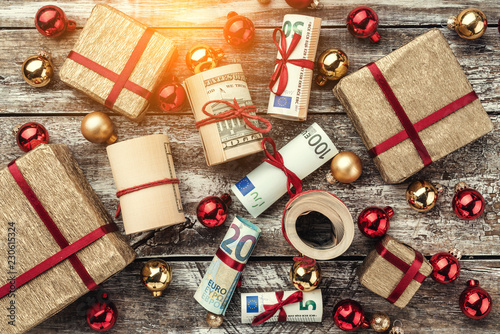 Old wooden background, American money, gifts and Christmas items. Top view. Different values. Light effect.
